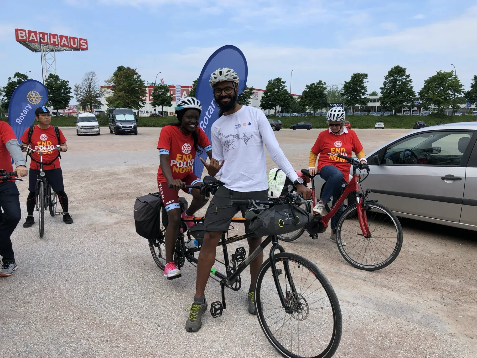 Naresh on the tandem with riders in red jerseys at a roadside stop